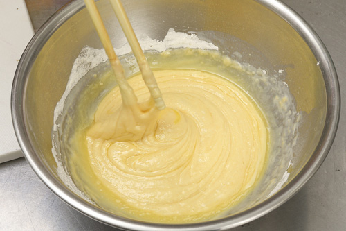 5. 生地<br>バターを電子レンジで加熱し、溶かす。溶かしたバターをボウルに入れ、牛乳、卵を加え、よくかき混ぜる。ホットケーキミックスを加え、さらに混ぜる。