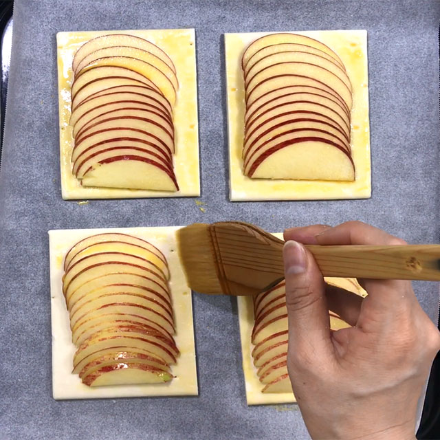 5. Dissolve yolk with water, then spread it on the sliced apples and pie by brush