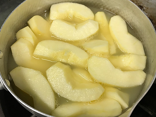 2. りんごを鍋に入れ、水（分量外）を加えて火にかける。りんごが柔らかくなったら火からおろし、ザルにあげ煮汁を切ってさましておく。 