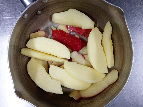 2. 鍋にりんごの皮を敷き、その上に1をのせ、レモン汁をふりかける。その中にはちみつを加えて、中火で約10分煮込む。