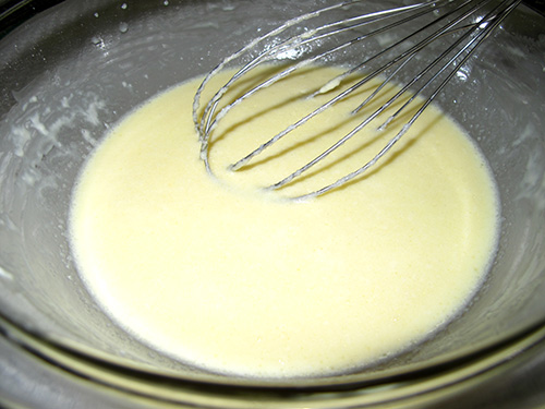 3. 残りの牛乳を少しずつ加えて完全に混ぜたら、溶かしバターを少しずつ垂らして混ぜる。