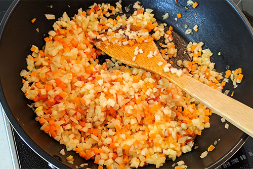 3. フライパンに油を熱し、玉ねぎ・にんじん・角切りにしたりんごを炒める。