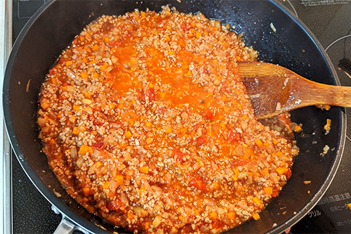 5. ひき肉の色が変わったら、カットトマト缶・コンソメ・トマトケチャップ・とんかつソース・すりおろしりんごを入れて、混ぜながら5分くらい煮込む。