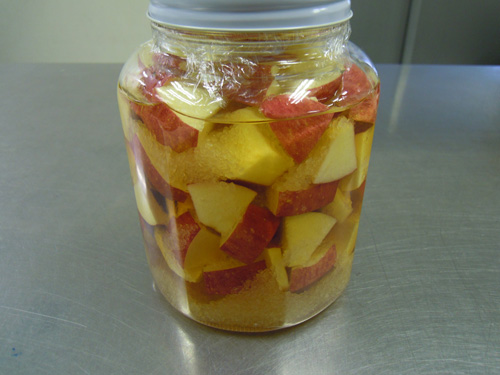 3. 瓶にりんご、中ザラメを交互に入れ、その上から穀物酢を注ぐ。