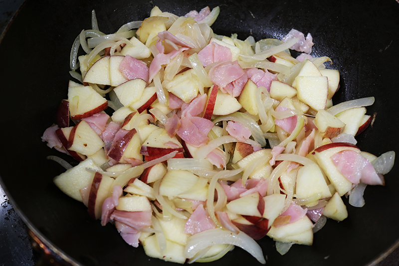 3. 具材<br>りんごは皮つきのままいちょう切り、玉ねぎは薄切りにし、ベーコンは2cm幅に切る。<br>フライパンにバターを溶かしてりんご・玉ねぎ・ベーコンを中火で炒める。
