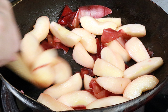 8. 中火で水分がなくなるまで炒め煮にする。<br>（皮と一緒に炒め煮にすることで、りんごがピンク色になる）<br>水分が飛んだら皮を取り出し、シナモンパウダーを入れひと混ぜして火を止める。