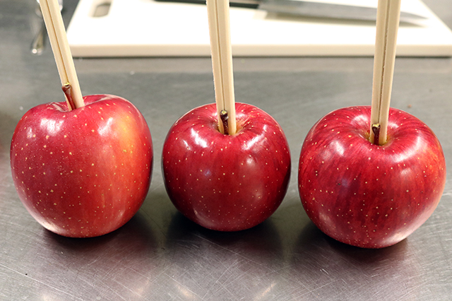 1. りんごは水で洗い、きれいに拭いておく。<br>りんごに割り箸を刺す。<br>※貫通させないように注意