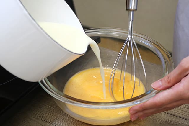 2.ボウルに卵を割り入れ、泡だて器でよく溶きほぐす。混ぜながら１を加え、しっかりと混ぜ合わせ、バニラエッセンスを加えてさらによく混ぜる。